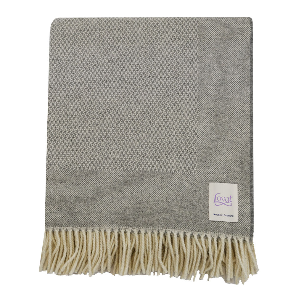 A pebble grey diamond border blanket with fringing, made from 100% lambswool.