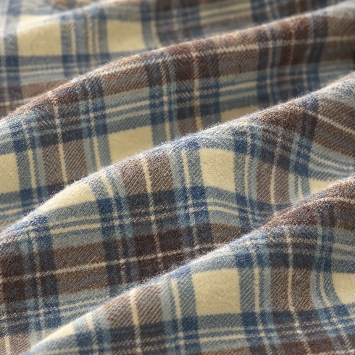 Close-up of the Stewart Muted Blue tartan lambswool fabric, showing the weave in blue, cream and brown. [swatch]