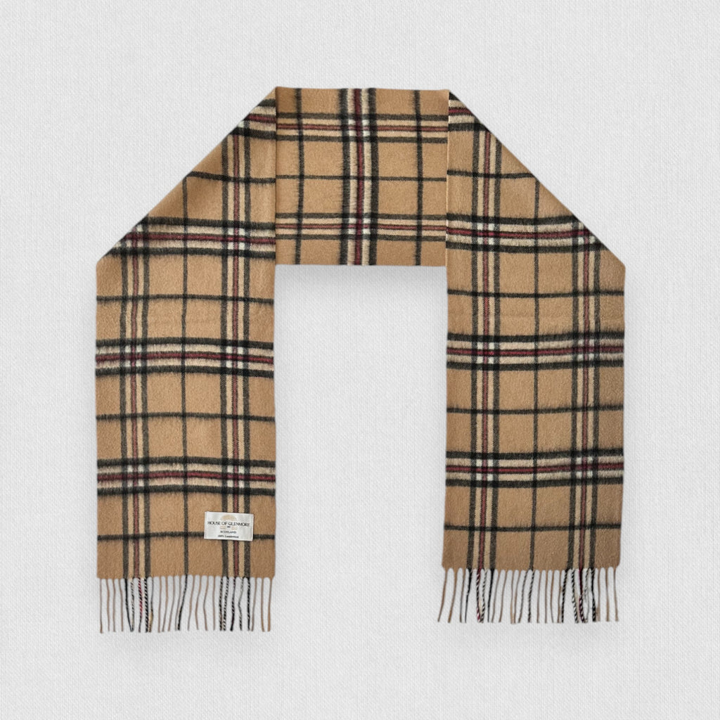 Camel thomson scarf with white fringe on a light gray background