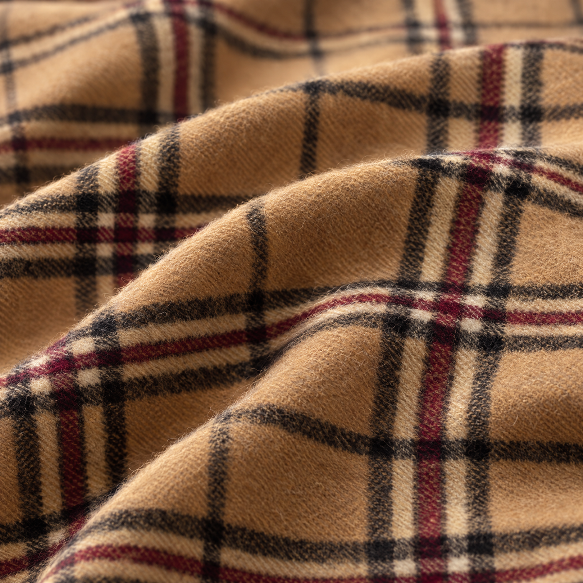 Close-up of the Camel Thomson tartan lambswool fabric, showing the weave in beige, black and red. [swatch]