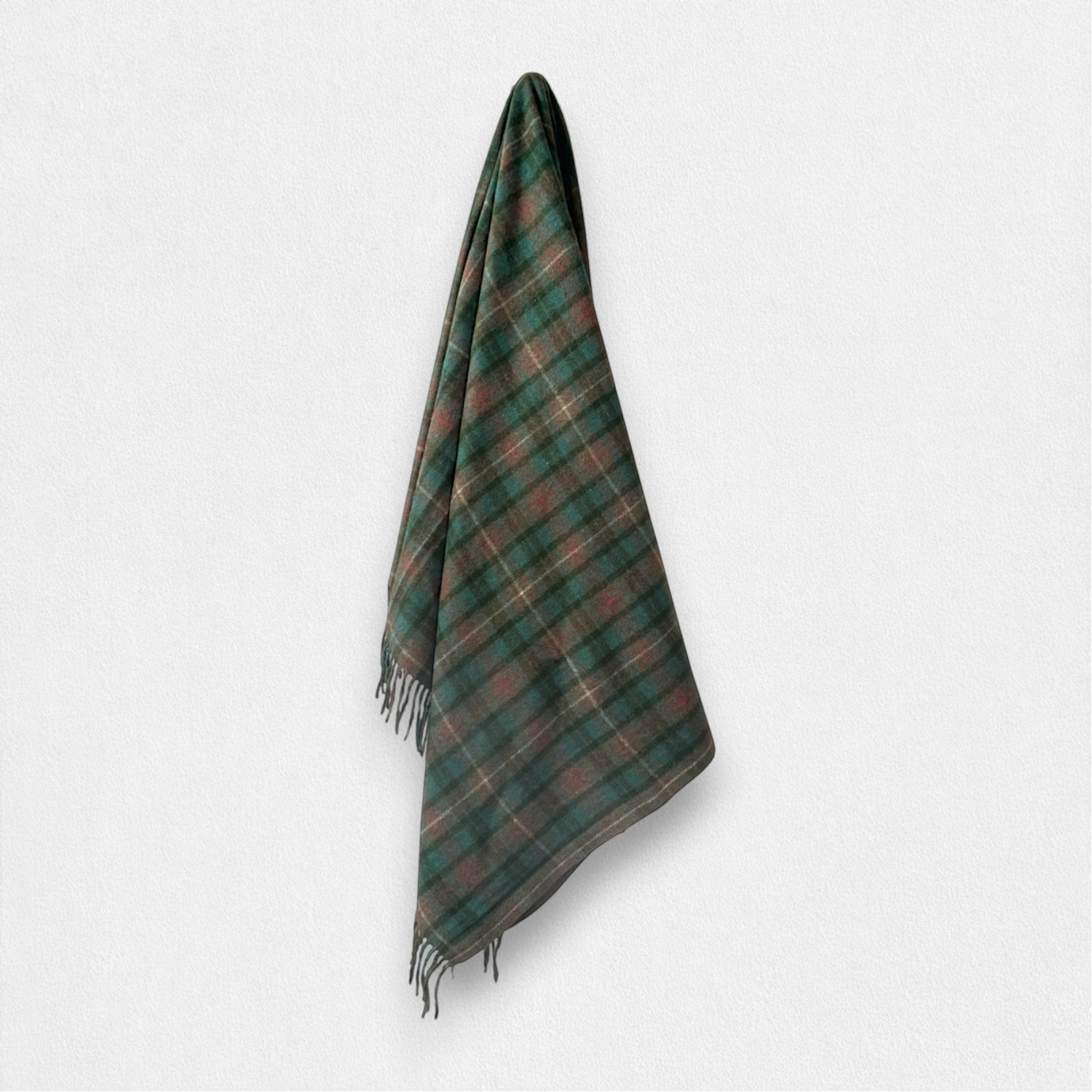 A dark green and brown tartan plaid scarf with fringed edges, hanging against a plain light gray background.