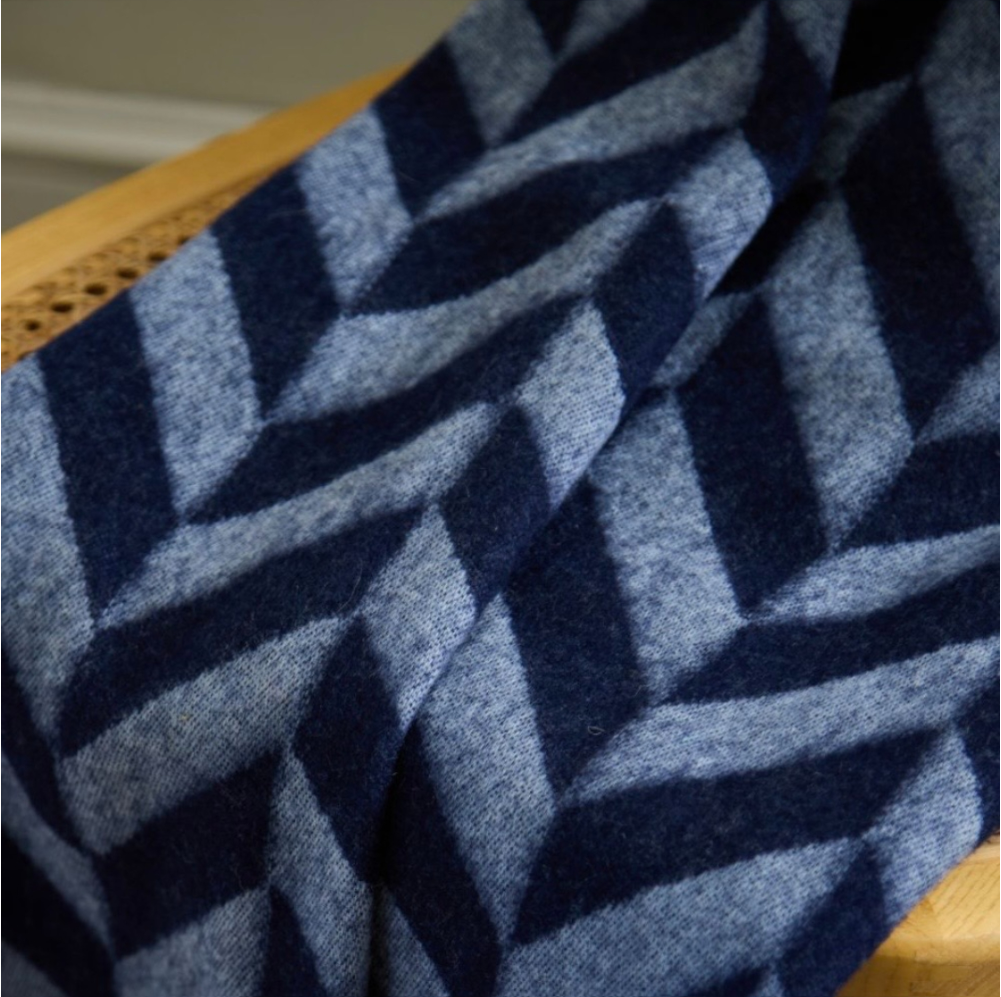 A 100% lambswool blanket from Loom & Cove, laid flat showing the fringed edge detail.