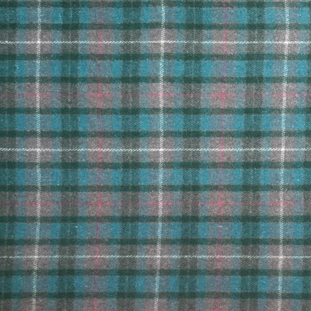A close-up of a plaid fabric pattern with teal blue, dark green, pink, and white intersecting stripes.