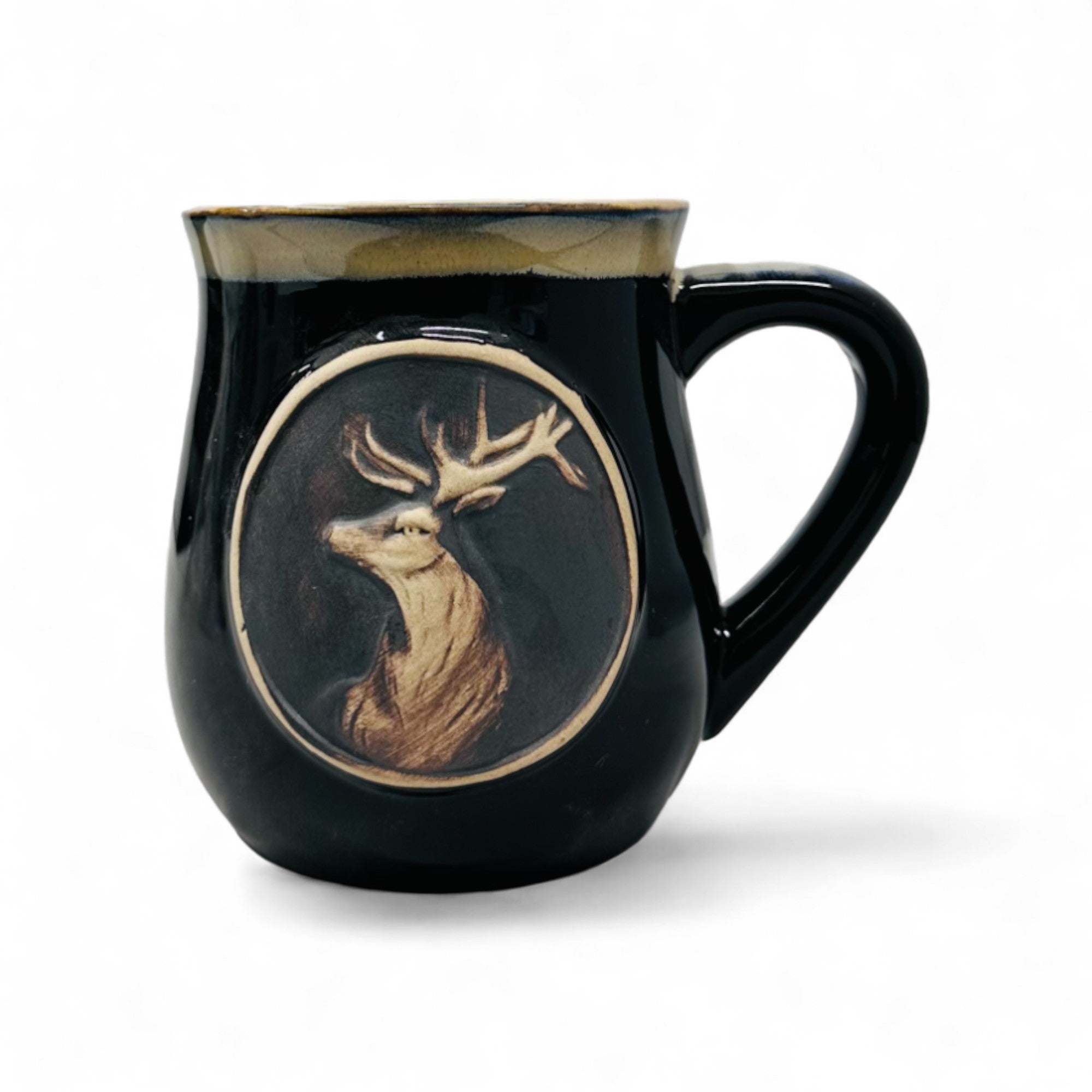 A black stoneware mug with a stag head design in a circular frame on the front.