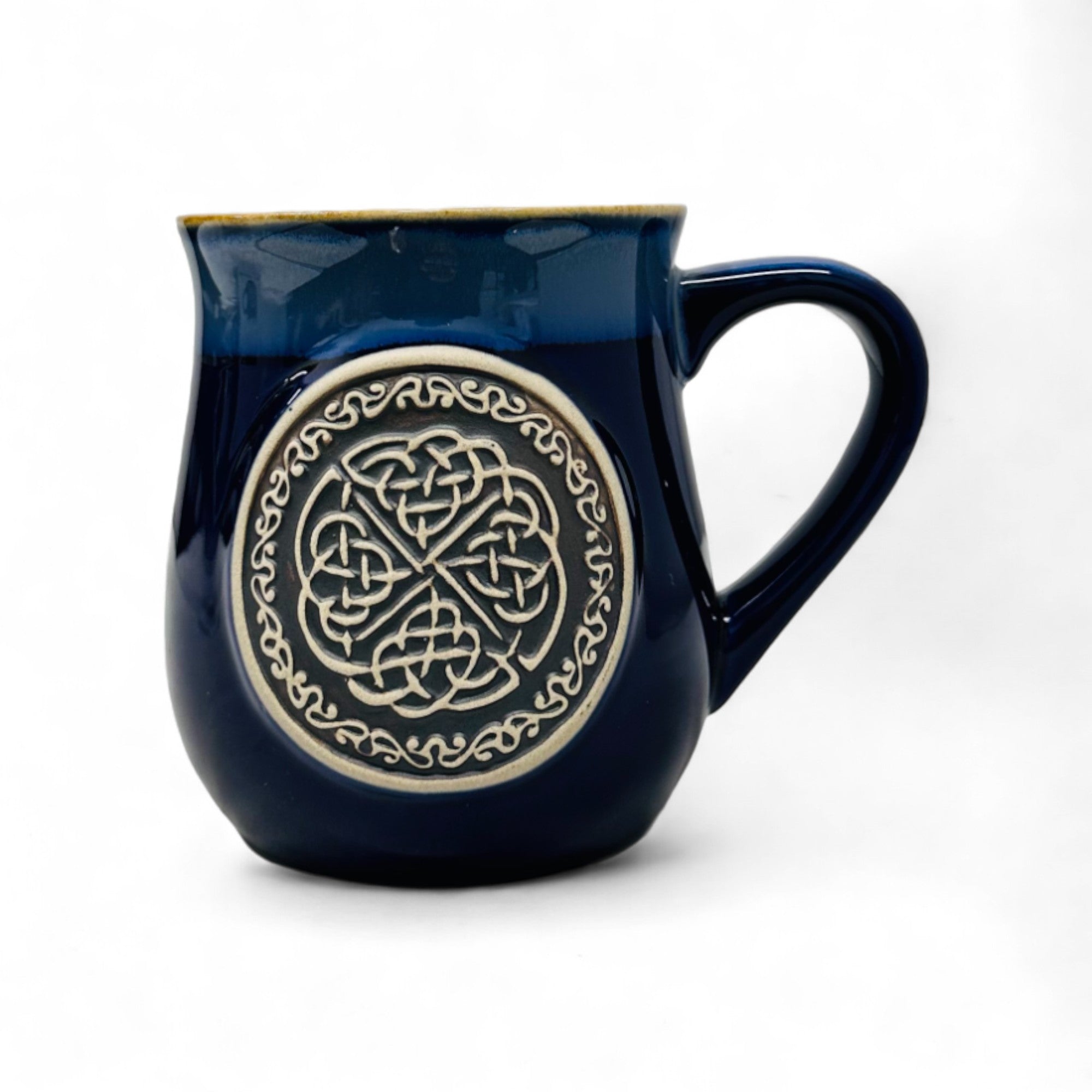 A blue stoneware mug with a Celtic circle design in the center.