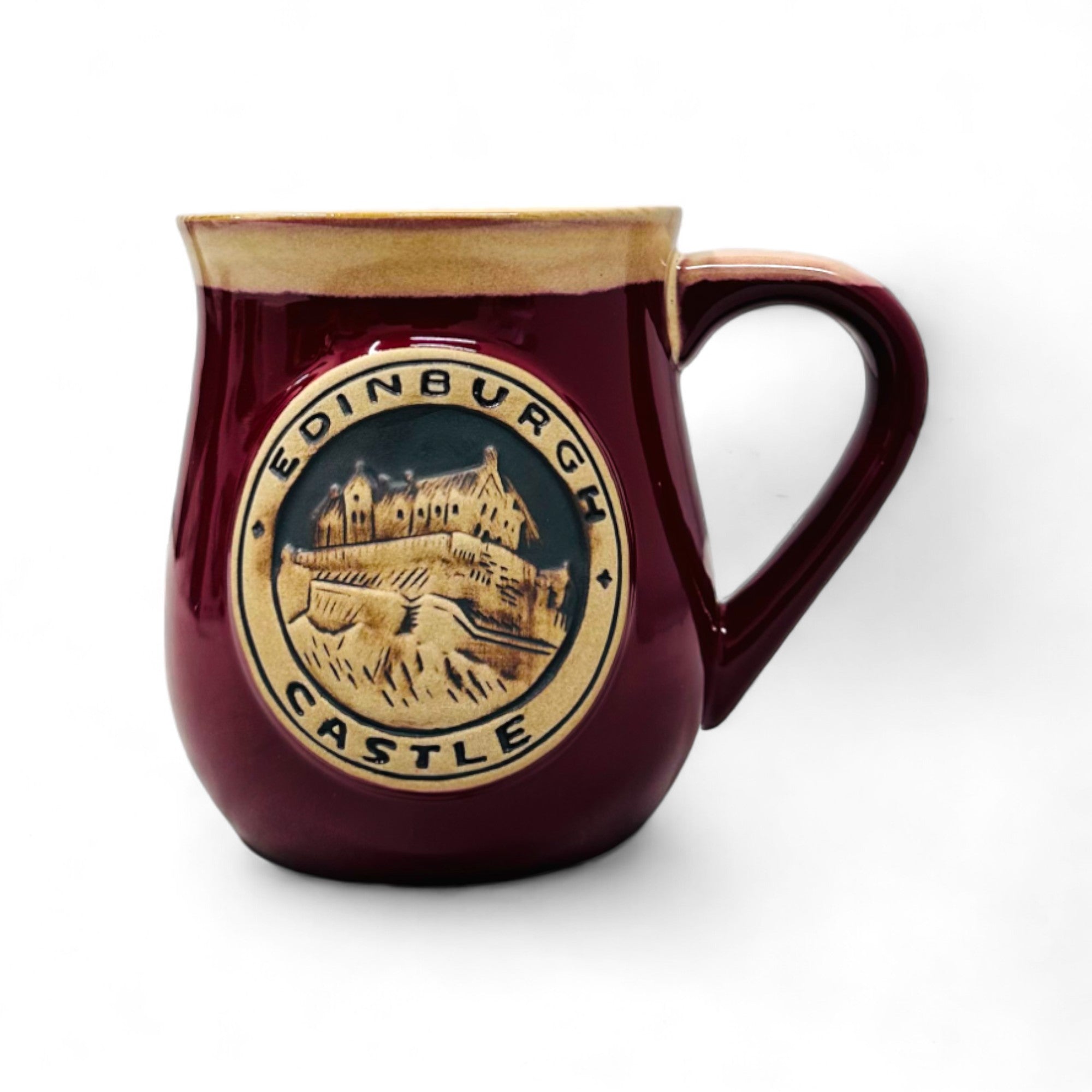 A red stoneware mug with a detailed Edinburgh Castle design in the center.