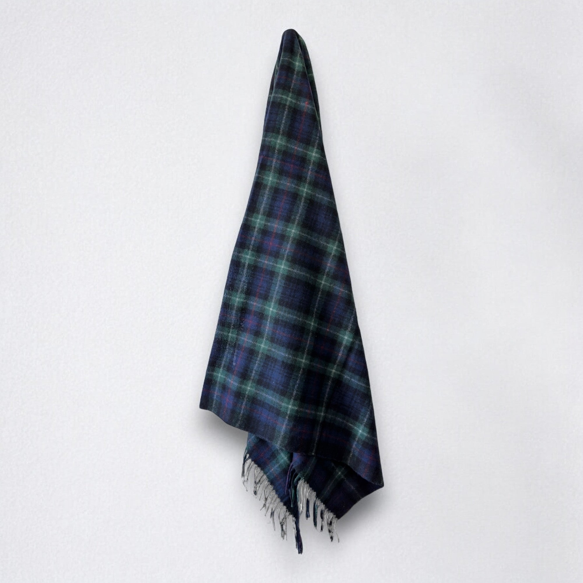 a 100% recycled blanket in mackenzie tartan hanging from a wall hook on a white background 