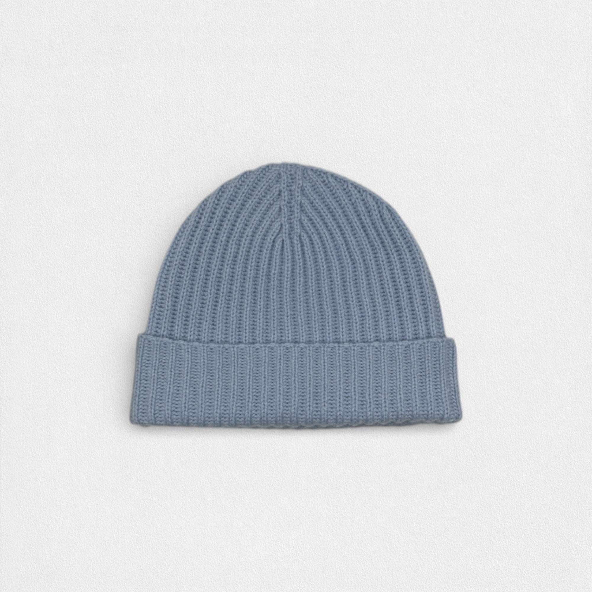 Blue knit beanie on a light gray background