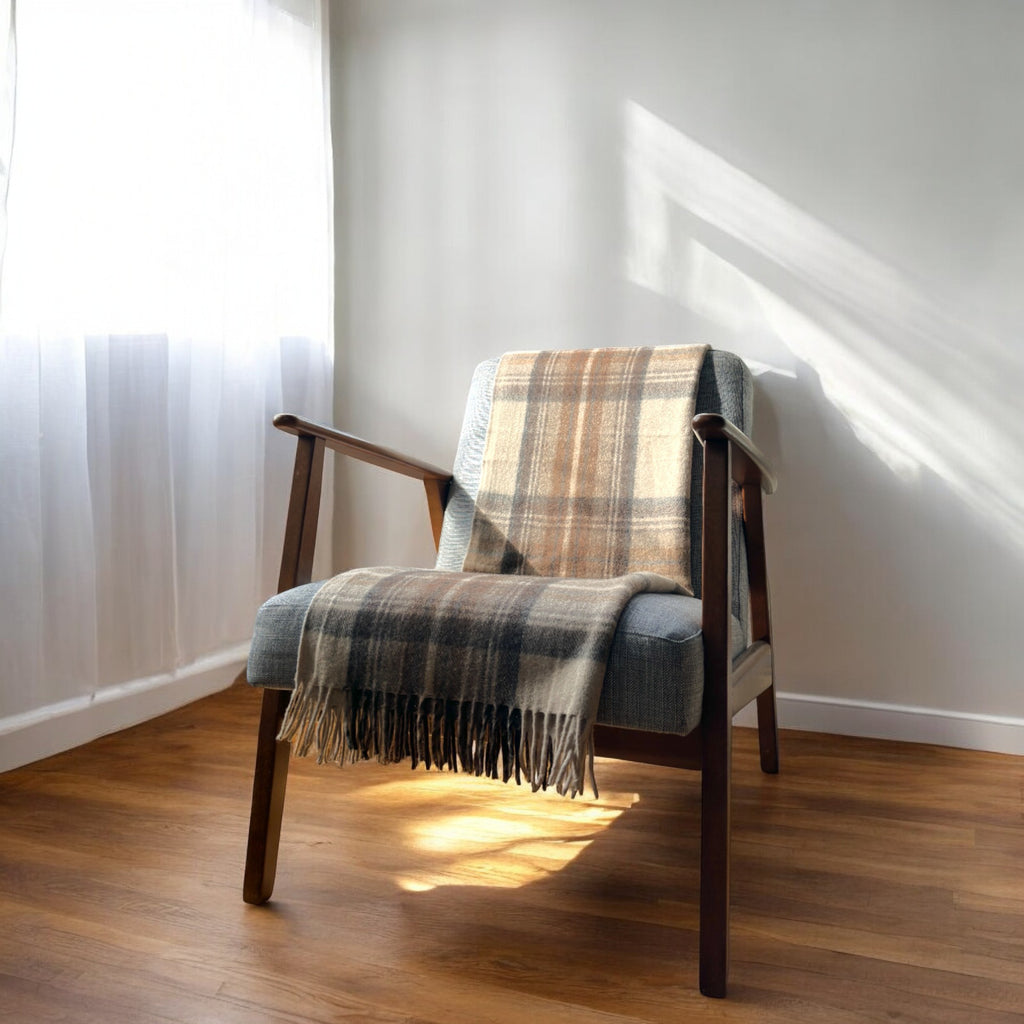 a natural dress 100% recycled knee blanket draped over a chair in a cosy room