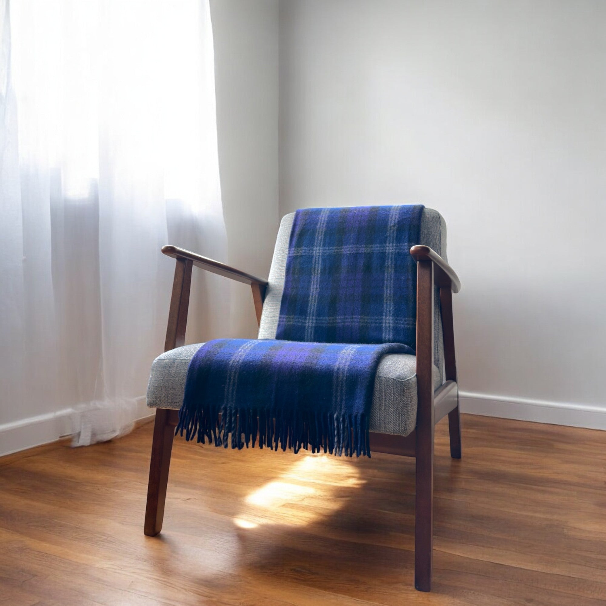 a scottish heritage 100% recycled knee blanket draped over a chair in a cosy room