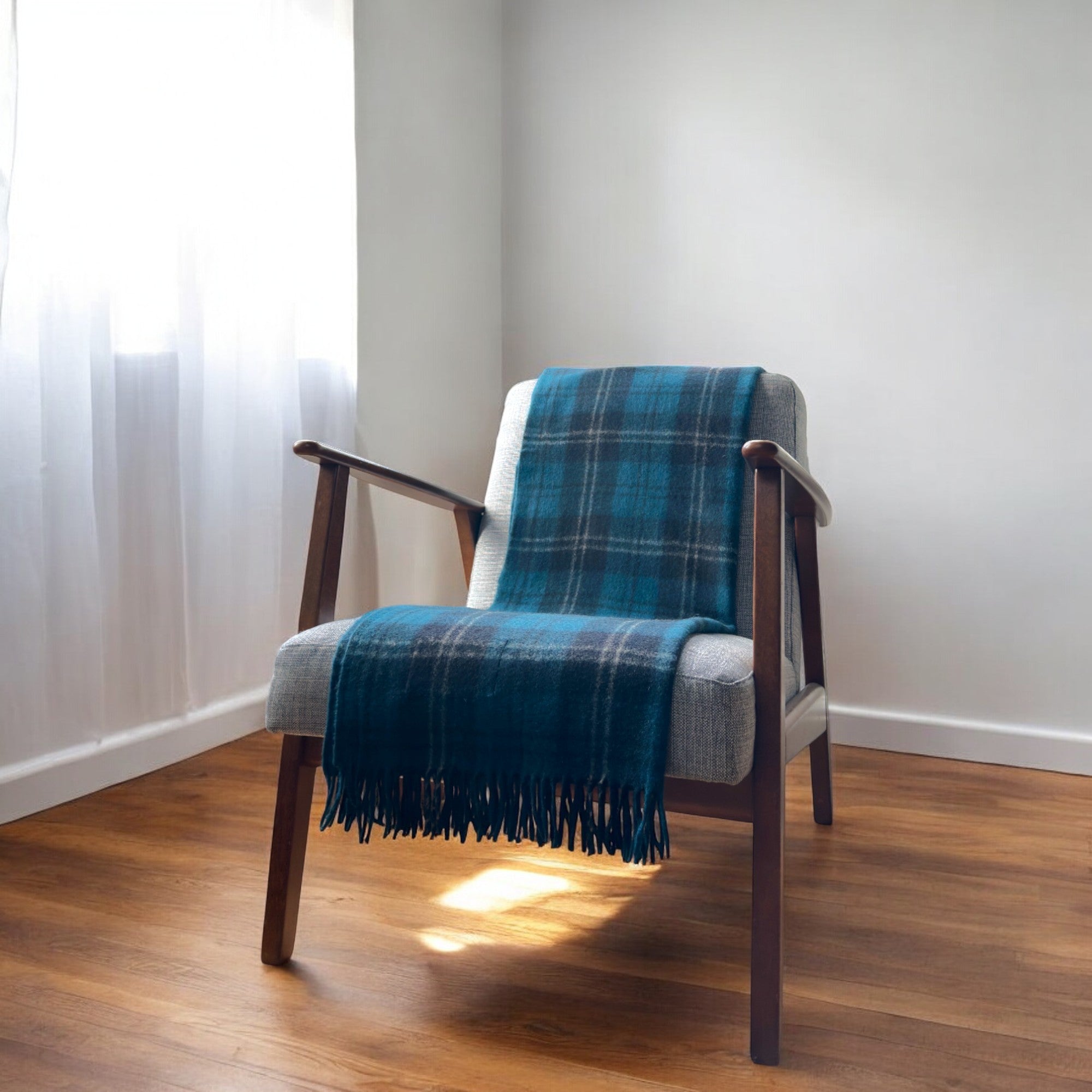 a ramsay blue 100% recycled knee blanket draped over a chair in a cosy room