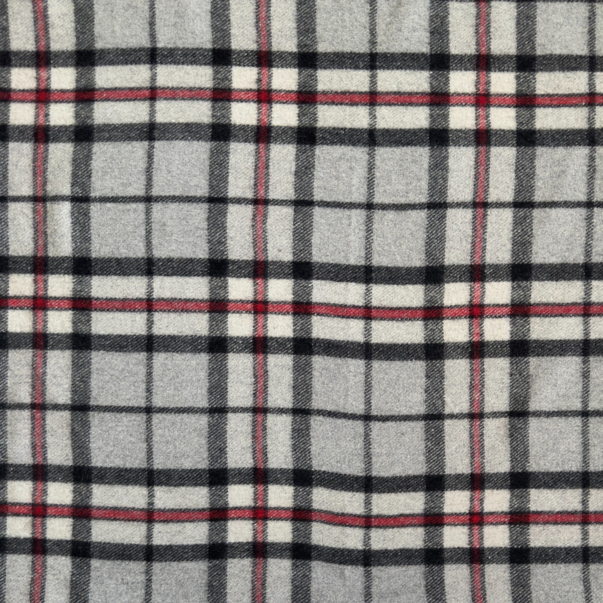 A close up of the Thomson Grey tartan. Thomson Grey tartan has grey, red, black and white stripes in a checkered pattern.