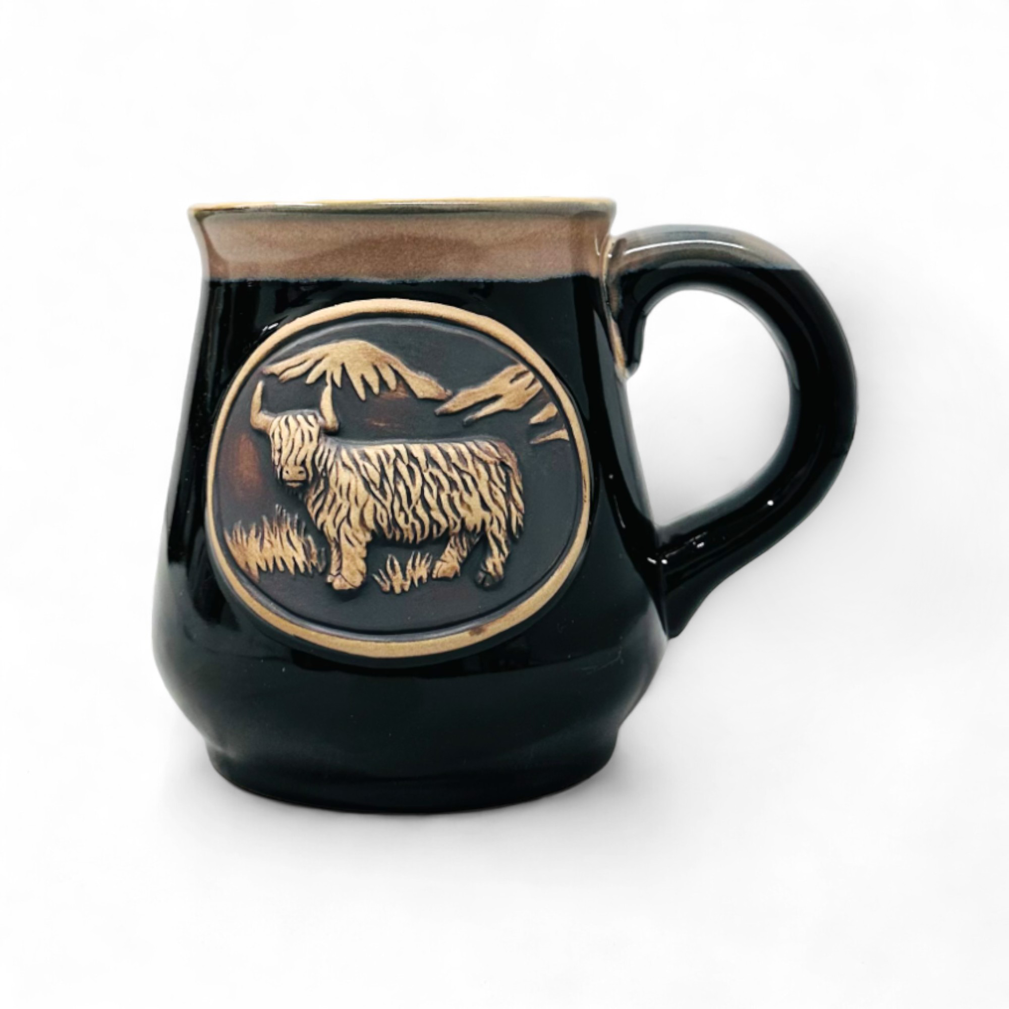 A black stoneware mug with a detailed Highland Cow design in a circular pattern on the side.