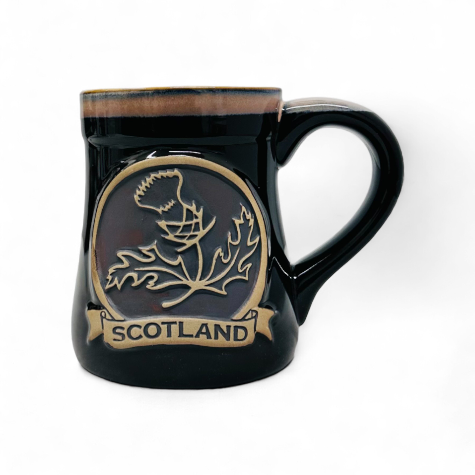 A black stoneware mug with a thistle design and 'SCOTLAND' text around it.