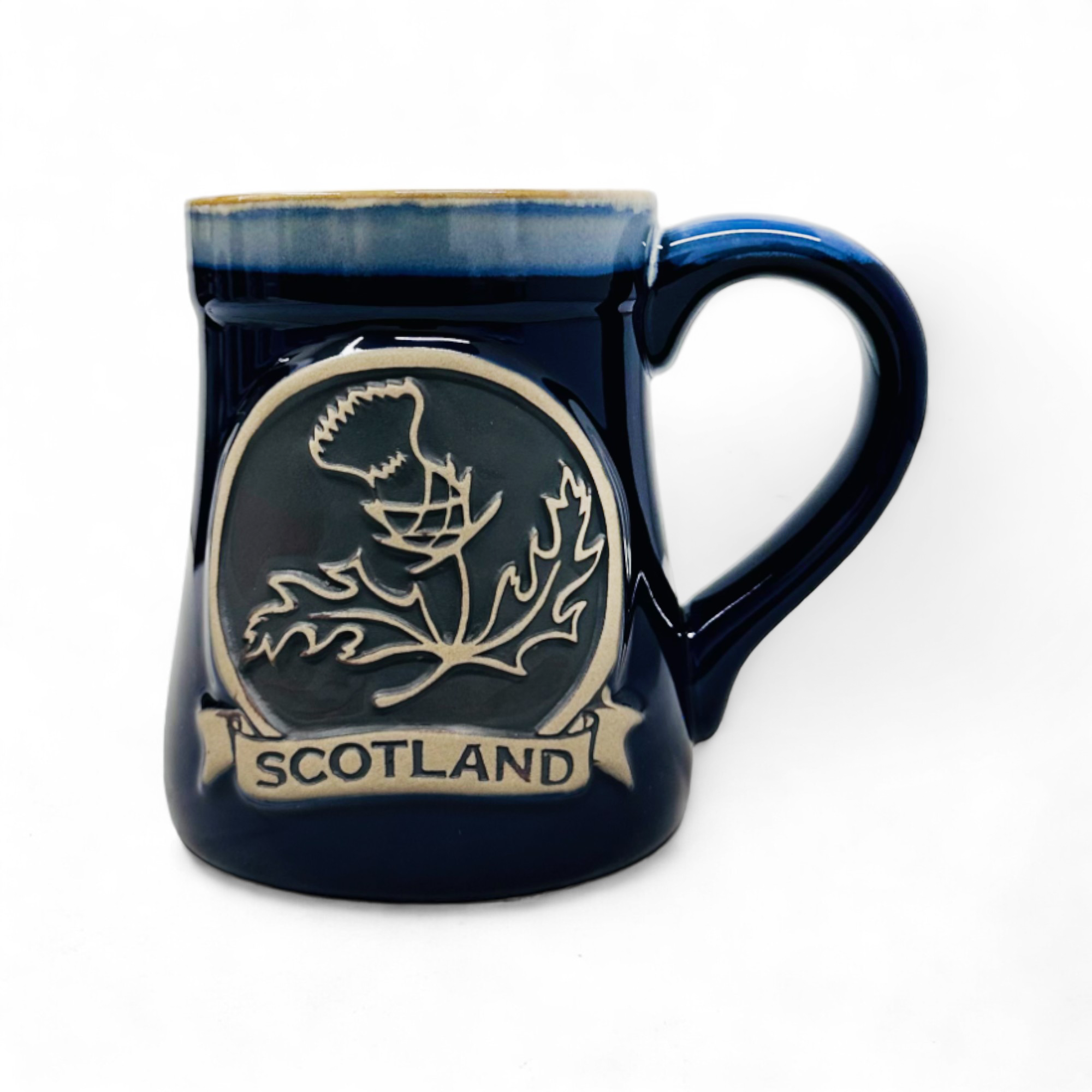 A blue stoneware mug with a detailed thistle design and 'Scotland' text on the front.